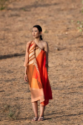 Brown and orange abstract print one-side off-shoulder dress styled for resort evenings, crafted in plant-based Japanese fabric, offering a modern silhouette for beach outfits, summer occasions and statement dressing.