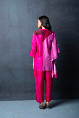 Back look of two-piece fuchsia pink dupion silk set comprised of abstract geometric print with bell sleeves and parallel pants with fusion textile play of abstract print. Perfect co-ord for Resort, loungewear, vacation, summer holidays, brunch, formal events.