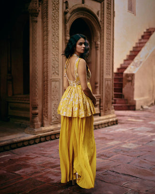 Back look of tuscany yellow peplum set Wedding Festivities, Day Outings, Cultural Events. It has intricate hand embroidery on the front and back of the yoke, with hand-embroidered lace detailing. It is paired with solid palazzos.