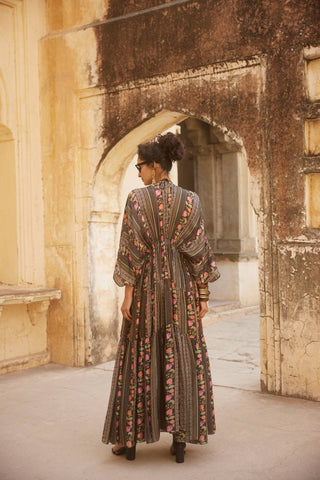 Model posing to show the back of the kaftan.