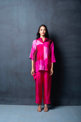 A two-piece fuchsia pink dupion silk set comprised of abstract geometric print with bell sleeves and parallel pants with fusion textile play of abstract print. Perfect co-ord for Resort, loungewear, vacation, summer holidays, brunch, formal events. Designed by Clos.