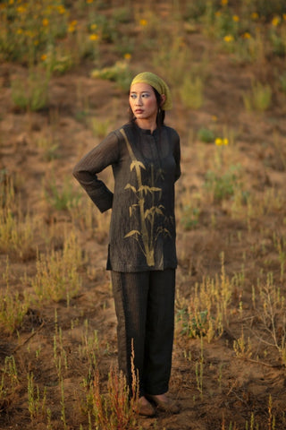 Model in a three-piece co-ord set comprises of a collared shirt pattern with long cuff sleeves expressing abstract prints designed by Clos, paired with pants and the cotton inner.