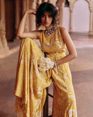 Close up of yellow jumpsuit featuring Roop flip bird print. The print is enhanced with hand-embroidery in zardozi and aari work and the look is complete with a printed belt. Perfect women's wear for cocktail, wedding, parties and special occasion.