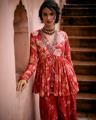 Close up of crimson red peplum featuring Roop flip bird print. The yoke and sleeves are hand-embroidered and the peplum has drawstring detailing with delicate tassels. It is paired with printed palazzos. Perfect outfit for cocktail and special occasion.