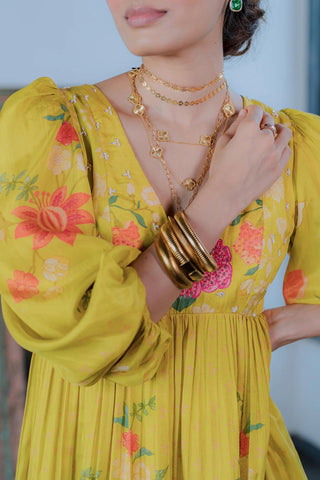 Close up look of Yellow Floral Maxi Gown Dress with ruffle sleeve styled with golden jewelries. The pink florals add a pop of color to this beautiful silhouette. It is adorned with hand–highlighted flowers on the yoke.