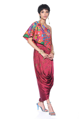 A striking fusion of tradition and modern style Crimson Red One-Shoulder Top paired with a Maroon Paisley Drape Skirt Boho chic fusion fashion for cocktail parties, festive events. Designed by Siddharth Bansal