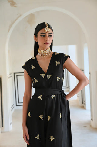 An elegant black silk Indo-Western jumpsuit adorned with delicate gold butti embroidery — a modern silhouette that celebrates the beauty of traditional craftsmanship. Perfect for the woman who loves contemporary fashion with an ethnic touch. Style it for cocktail parties, birthday celebration, festive or wedding welcome parties.