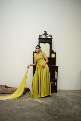 Woman in a green traditional outfit posing to show the ethnic designer look of the anarkali dress. Designed by Ease. Hand embroidery craftmanship.