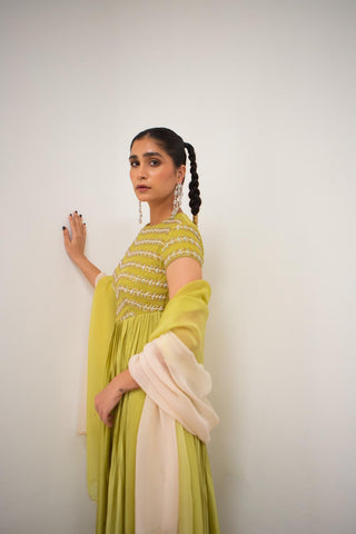 Woman in a green traditional outfit posing to show the ethnic designer look of the anarkali dress with ombre dupatta. Indian designer attire perfect for any ethnic occassion.