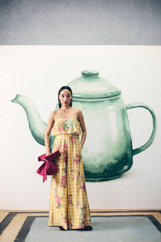 Model in yellow sleeveless jumpsuit featuring artistic placement prints, trendy and elegant outfit ideal for casual wear, travel, brunch dates, and modern chic styling.