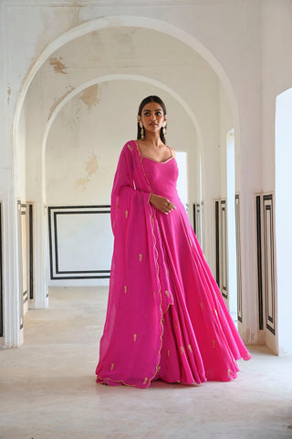 Crafted for the modern muse, this statement Anarkali features intricate butti embroidery that adds a touch of timeless charm. The flattering godet panels create a graceful flow, while the delicate spaghetti straps bring in a hint of contemporary allure. Paired with a matching dupatta, this ensemble is perfect for soirées, festive celebrations, and wedding festivities. Designed by Ease.
