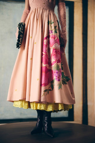 Elegant soft pink dress featuring smocked waistband, gathered front detailing, and feminine floral placement print.