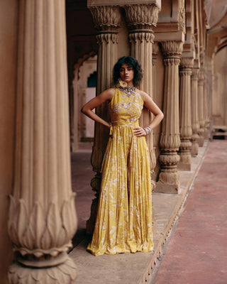 A Tuscany yellow jumpsuit featuring Roop flip bird print. The print is enhanced with hand-embroidery in zardozi and aari work and the look is complete with a printed belt.  Designed by Paulmi and Harsh. Perfect outfit for cocktail, wedding, parties and special occasion.