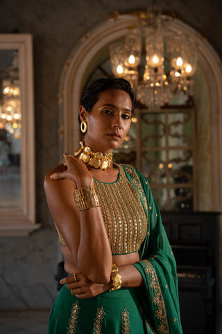 Model posing to show the close up of gold dori and a mirror embellished blouse