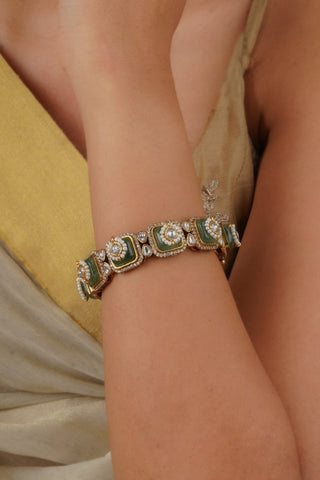 women wearing elegant green kundan kada with moissanite and zircon detailing in gold finish, single piece bangle with screw closure, ideal for bridal and traditional occasions.