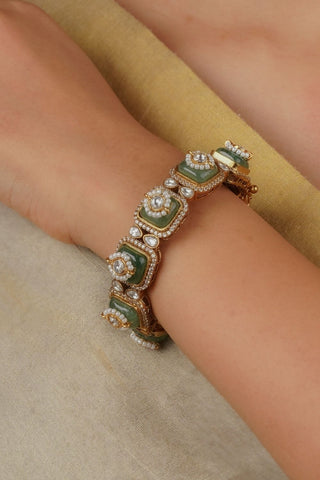 Statement green kundan kada with intricate design, embellished with moissanite and zircon stones, gold plated with screw fastening for a rich traditional look. Ideal for bridal wear and festive occasions