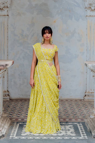 Featuring a moss green hand block jaal printed tiered skirt in georgette base with draw string and tassels paired with a moss green embroidered blouse in silk with cutwork neckline and cap sleeves. It comes with a matching silk embroidered waist belt and moss green georgette hand block jaal printed pre-pleated draped dupatta. Designer - Ivory By Dipika
