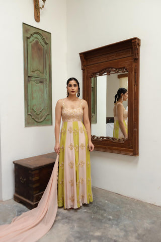 Woman in a pink and yellow dress standing in front of a mirror posing to show the embroidery and designs of the anarkali dress in ombre colours. Designed by Ease.