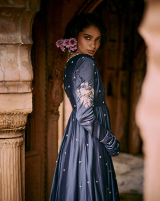 Woman in a blue anarkali embroidered dress standing in an architectural setting. A desi vibe for any girl who wants to celebrate her roots.
