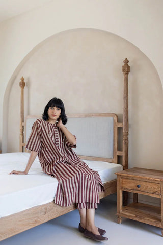 Seated model in relaxed maroon striped cotton kurta and pant set