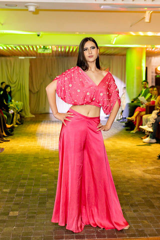 Elevate your style with our Pink Gathered Crop Top ensemble, a fusion of modern aesthetics and traditional elegance. The crop top, featuring delicate Pearl Embroidery, captures the essence of opulence. Teamed with flared palazzo pants, this ensemble is a celebration of boldness, grace, and sophistication. Perfect for daytime soirees, cultural events, and occasions where you want to make a radiant impression. Designed by Mona and Vishu