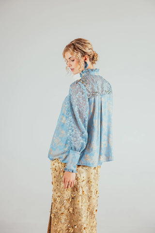 Light blue satin blouse and delicate lace detailing, creating a refined feminine look suited to elevated occasion and evening styling.