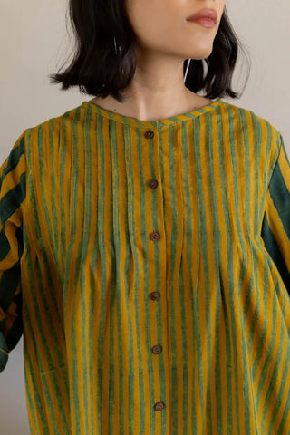 Close-up of pintuck detailing and wooden buttons on hand block printed mustard green tunic