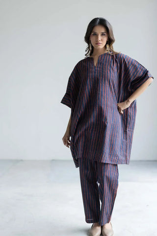 Model wearing navy and rust striped cotton kaftan top with matching straight pants, front view