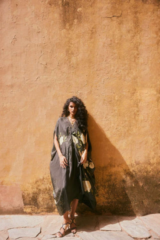 Elegant floral silk kaftan with soft drape and knot detailing, paired with a black slip for sophisticated resort evenings.