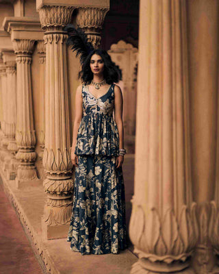 A navy blue peplum set in Paulmi and Harsh signature Roop flip bird print, featuring a pair of birds in their enchanting habitat. The peplum is hand-embroidered with lace on the neckline, and hand-embroidery on the yoke, lending royalty to the breezy silhouette. Designed by Paulmi and Harsh. It is a chic and elegant outfit. Perfect for Weddings & Receptions, Cocktail Parties, Festive Gatherings, Engagement & Sangeet Nights, Formal Dinners & Evening Soirées.