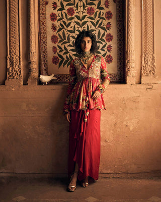 A red floral map printed peplum, with delicate hand–embroidery on the yoke and sleeves and drawstring detailing with beautiful tassels. It is paired with a red skirt. Designed by Paulmi and Harsh. Perfect outfit for cocktail and special occasion.