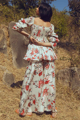 Back look of the designer off-white bird print co-ord set featuring a peplum blouse with bishop sleeves and flowy palazzos.