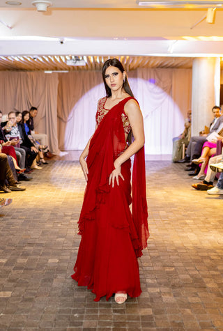 Runway model flaunting crimson red chiffon ruffle pre-drapped pre-stitched saree, paired with a silk hand-embroidered blouse in delicate chintz motifs at Australian Fashion Grandeur runway.