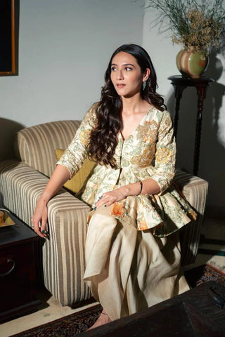 A printed peplum, featuring delicate hand-embroidery on yellow and orange floral print. It is paired with a pre-draped skirt. Your go-to look for wedding celebrations, pre-wedding festivities and unforgettable special occasions.