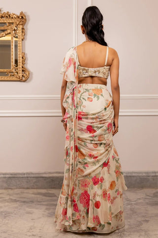 Back look of sleeveless blouse with intricate hand embroidery detailing and layered ruffle detailing on delicate georgette floral saree.