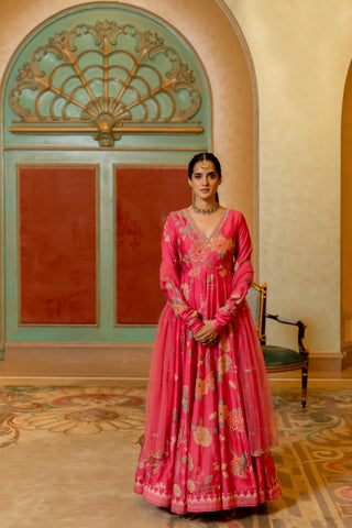 Blooming pink V-neck Anarkali in signature floral print, hand-highlighted with antique sequins, cutdana, mirrors, and resham, paired with a net hand-embroidered dupatta — perfect for weddings and festive occasions.