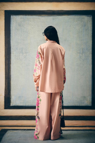 Back look of elegant pink poplin outfit highlighting clean tailoring and relaxed contemporary styling.