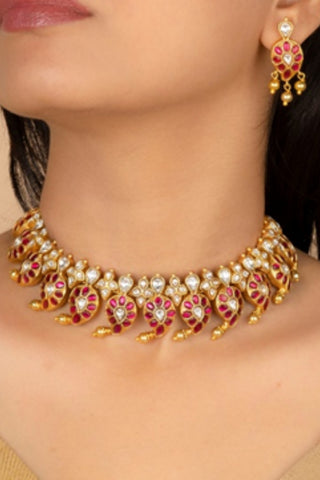 Women in traditional antique gold plated Jadau stone necklace set with matching earrings. Perfect accessory to pair with sarees, lehenga for wedding, parties and events.