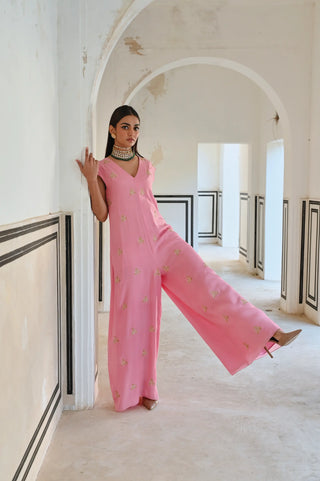 An elegant pink Indo-Western jumpsuit adorned with delicate gold butti embroidery — a modern silhouette that celebrates the beauty of traditional craftsmanship. Perfect for the woman who loves contemporary fashion with an ethnic touch. Style it for cocktail parties, festive celebrations or wedding ceremonies.