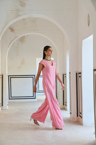 An elegant pink Indo-Western jumpsuit adorned with delicate gold butti embroidery — a modern silhouette that celebrates the beauty of traditional craftsmanship. Perfect for the woman who loves contemporary fashion with an ethnic touch. Style it for cocktail parties, festive celebrations or wedding ceremonies.