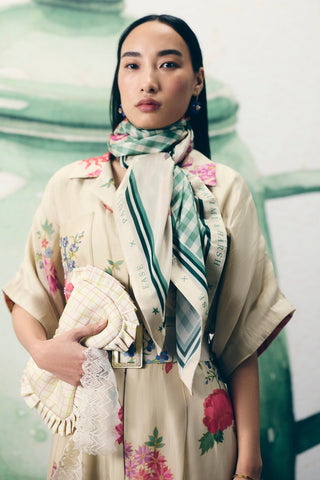 Refined ivory jumpsuit with a classic collar, intricate pocket embroidery, and a flattering tie-up waist belt. Perfect for creating a clean, sophisticated look for various occasions.