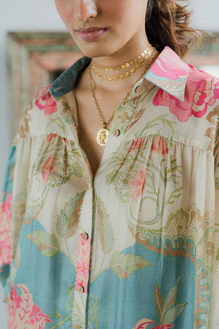 Close up of ivory shirt with blue and pink floral abstracts prints.  tailored from pure habutai silk. Resort wear, brunch to soiree, vacation in stlye, gen-z glam.