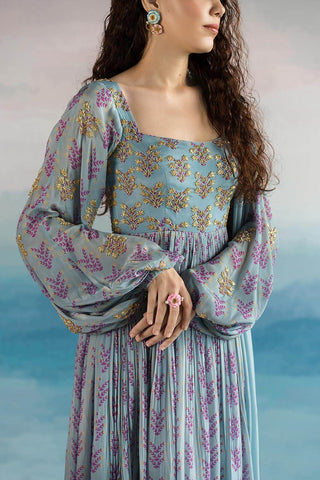 Model posing to show the left profile of the dress with long sleeves and heavy embroidered work on the top of the anarkali dress.