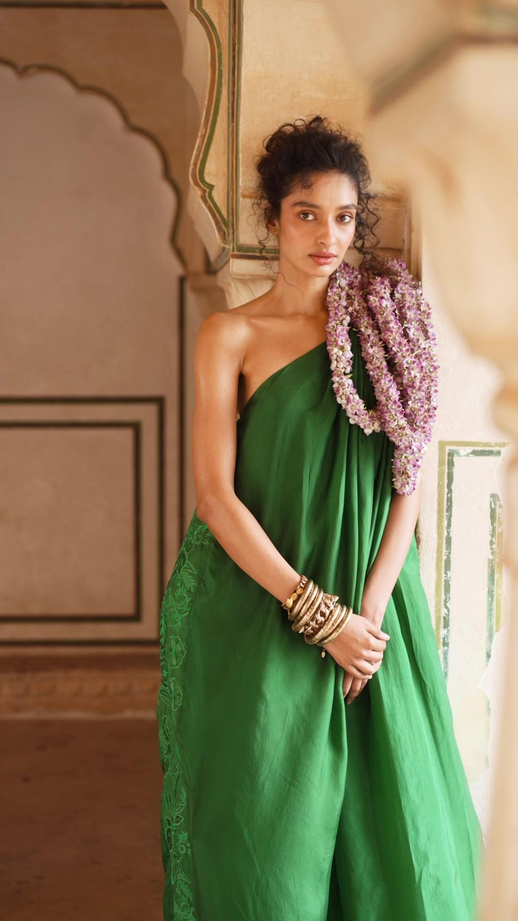 Model in Indo Western Emerald Green One Shoulder Maxi Dress with floral cutwork embroidery on habutai silk fabric designed by Paulmi and Harsh. A perfect women's outfit beach wear, party, summer wear, date dinner, dress to flaunt and style.
