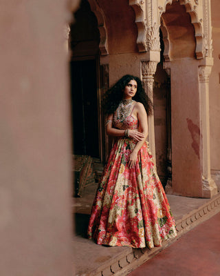A red map printed lehenga set with a heavily hand-embroidery strappy blouse, and hand-embroidery print highlights on the lehenga. It is paired with a scallop embroidered dupatta.