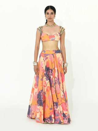A model stands against a plain white studio background wearing a two-piece traditional lehenga set crafted in luxurious crepe and organza fabric in a radiant buttercup yellow hue with multicolor accents. Designed by Rishi and Vibhuti. Perfect for weddings, festive celebrations, destination events, and special occasions.