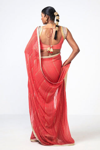 Back look of Red Chandini saree by Rishi and Vibhuti featuring sophisticated linear trim embroidery on premium georgette and Chanderi silk, styled with a matching blouse and petticoat for luxurious Indian festive and wedding wear