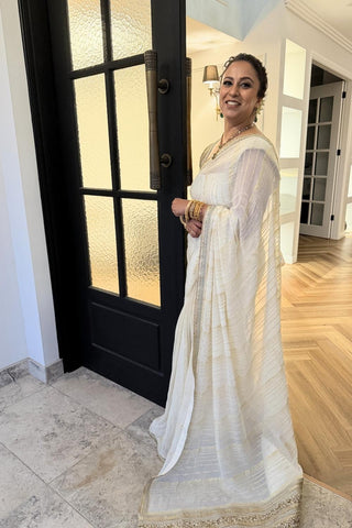 Designer ivory saree, Georgette & Chanderi Silk fabric, Linear trim golden embroidery on the border of the saree. Perfect for wedding and festive or special occasions.