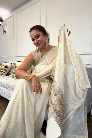 Designer ivory saree, Georgette & Chanderi Silk fabric, Linear trim golden embroidery on the border of the saree. Perfect for wedding and festive or special occasions.
