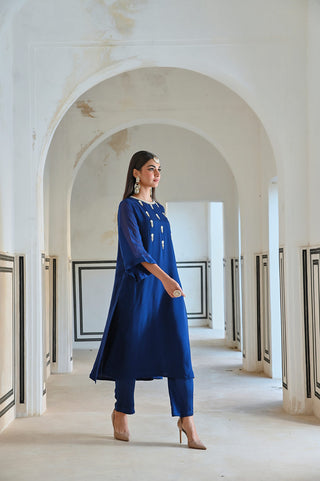 A royal blue floral butti kurta set with pant . A perfect dress for brides for side wedding ceremonies like welcome parties. 